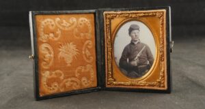 079-025-P0385, Tin type of a Union Soldier with a bummer cap and holding a Colt M-1860 Army. BUY NOW